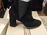 bottines en daim noir ornées d'un nœud blanc au talon