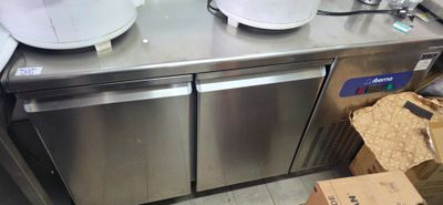 stainless steel counter top with two bowls on top of it and a box on the floor