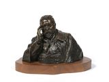 a bronze statue of a man sitting on a wooden base