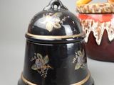 pair of black and gold decorated jars with a hammer in the top