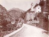 a black and white photo of a road with a church in the background