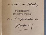 un livre ouvert, sur lequel est posée une note manuscrite, posé sur une table
