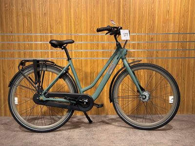 a green bicycle parked in front of a wooden wall