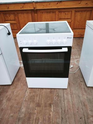 une cuisinière blanche avec un plan de cuisson en verre dans une cuisine