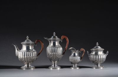 four pieces of silver tea and coffee set on a table