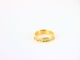 gros plan d'une bague en or sur une surface blanche