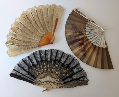 trois vieux ventilateurs sont exposés sur une surface blanche