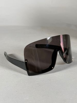 Les lunettes de soleil sont noires et ont une bande rose sur le côté.