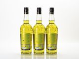three bottles of olive oil sitting on top of a white surface