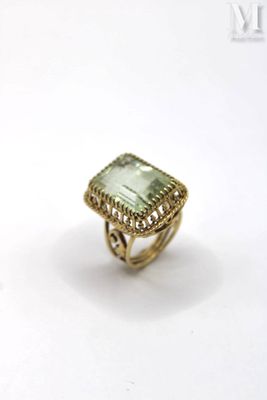 an image of a gold ring with a green stone in it