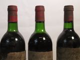three bottles of wine are lined up in a row on a table