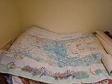un lit sur lequel est posée une carte, dans une chambre