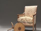 an image of a chair with a wooden wheel on a gray background
