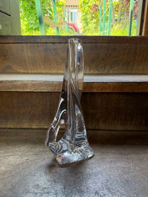 a glass vase sitting on a window sill in front of a window