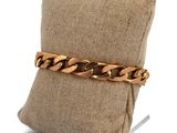gros plan d'un bracelet en chaîne en or sur un oreiller