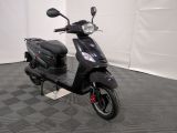 the motor scooter is parked in the garage on the floor