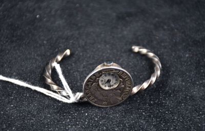 une photo d'un bracelet en argent surmonté d'une pièce