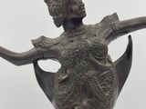 bronze statue of a woman holding a bird in her right hand