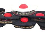 several hats with red pom poms are stacked on top of each other