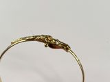 a close up of a gold ring with a lizard on it ' s side
