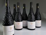 six bottles of wine are lined up in a row on a table