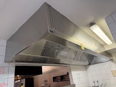 une photo d'une cuisine avec une cuisinière et une hotte aspirante