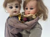 two dolls that are sitting next to each other