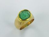 an image of a gold ring with a green stone in the center