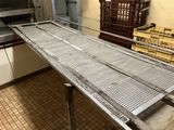 a metal conveyor belt in the middle of a kitchen