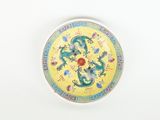 a yellow plate with a dragon on it on a white surface