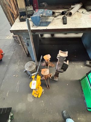 un tas d'outils posé par terre à côté d'une table