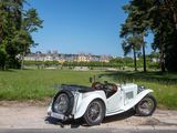 a white vintage car parked on the side of the road