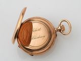 an antique pocket watch with a gold case and a chain