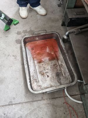une personne debout à côté d'une casserole sale posée par terre