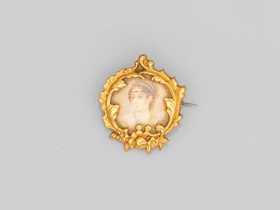 une broche plaquée or représentant le portrait d'une femme