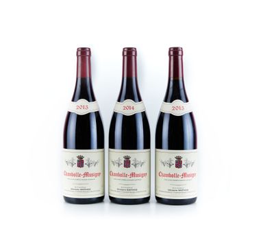 trois bouteilles de vin rouge posées sur une table blanche