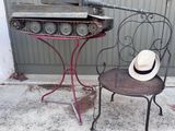 un chapeau posé sur une chaise à côté d'une table sur laquelle se trouve un bocal