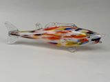 un poisson en verre posé sur une surface blanche