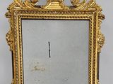 un miroir richement décoré, avec un cadre doré sur fond blanc