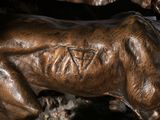 a statue of a dog that is laying down on a rock