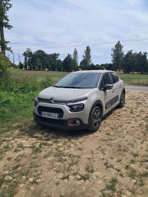 La voiture est garée sur le bord du chemin de terre.