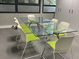 une table en verre avec quatre chaises dans une salle de réunion