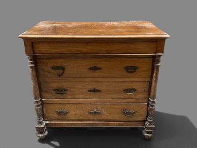a small wooden chest of drawers on a gray surface
