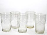 quatre verres sont alignés sur une surface blanche