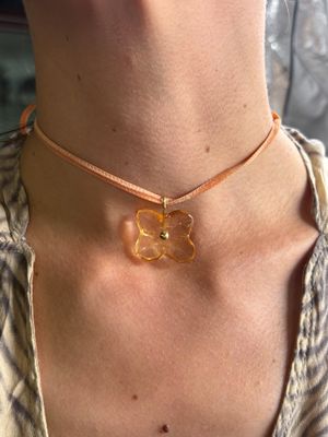 un gros plan sur une femme portant un collier orné d'une fleur