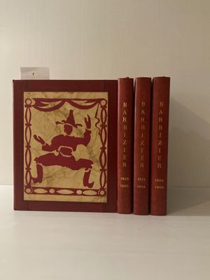 trois livres posés sur une table blanche