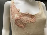an image of a mannequin wearing a beige top with a pink flower on it