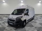 la camionnette blanche est garée dans une grande pièce au sol en damier