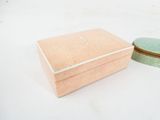 a small box with a lid sitting on a white surface
