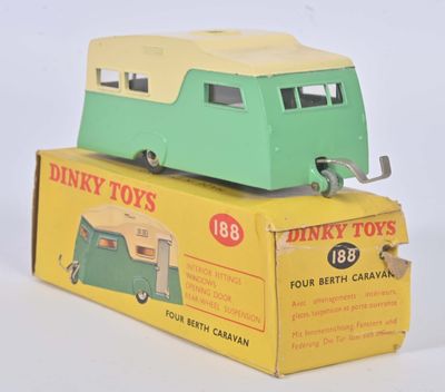 un petit camion jouet vert et jaune posé sur une boîte